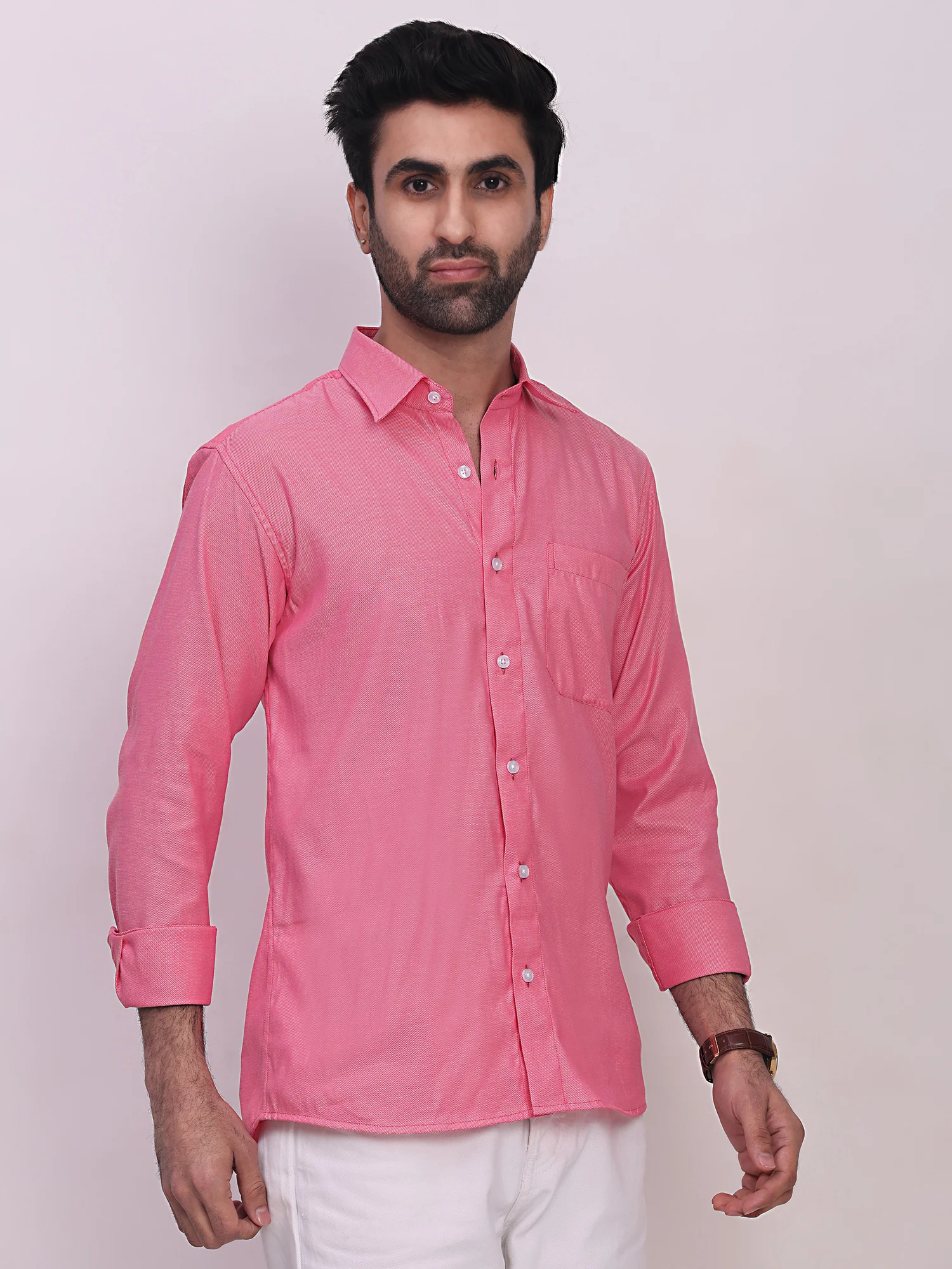 Model wearing a pink long-sleeve shirt with a front pocket, collar, and button closure