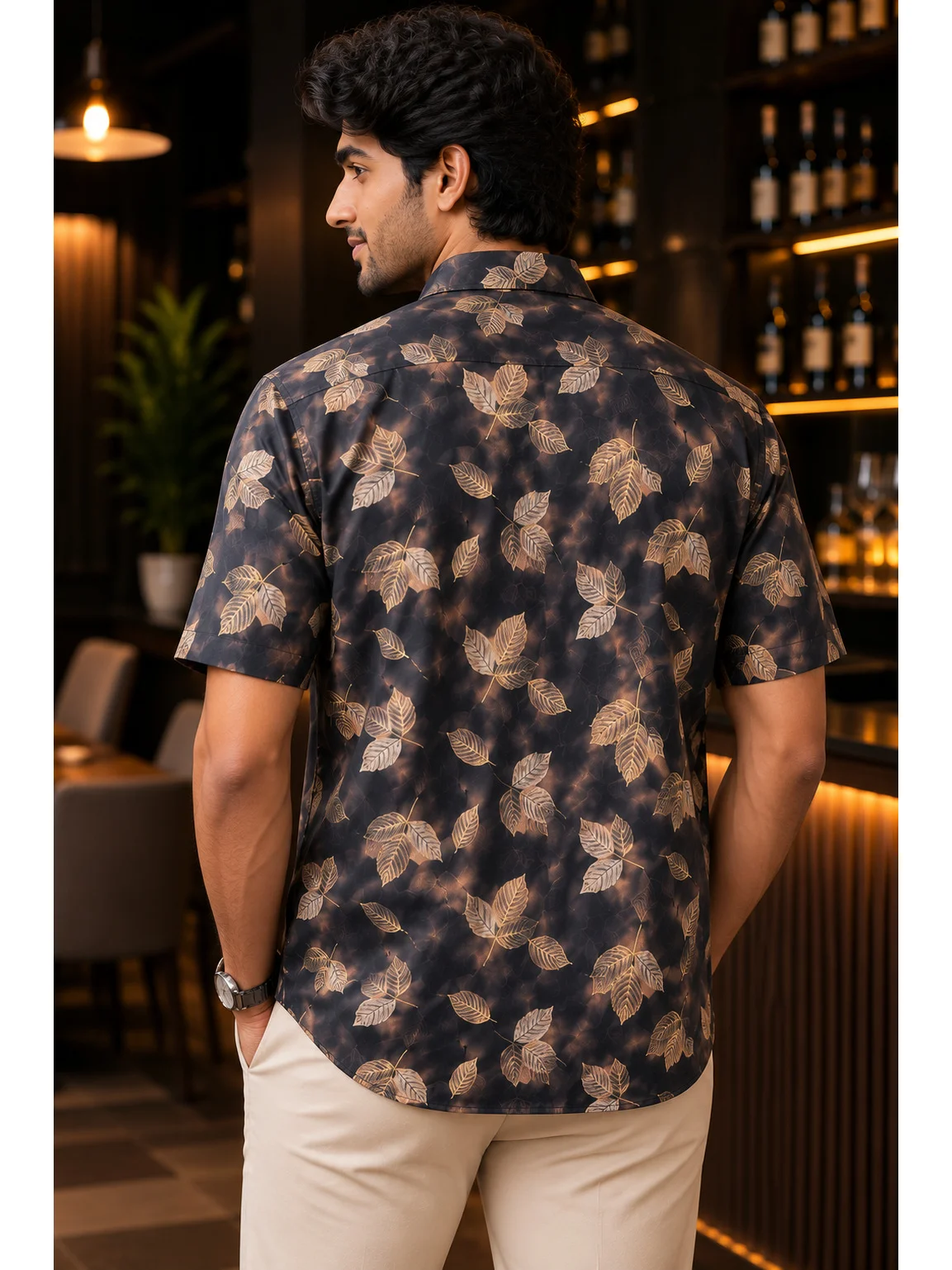 Short-sleeved shirt, black with beige leaf pattern, back view, worn by a model
