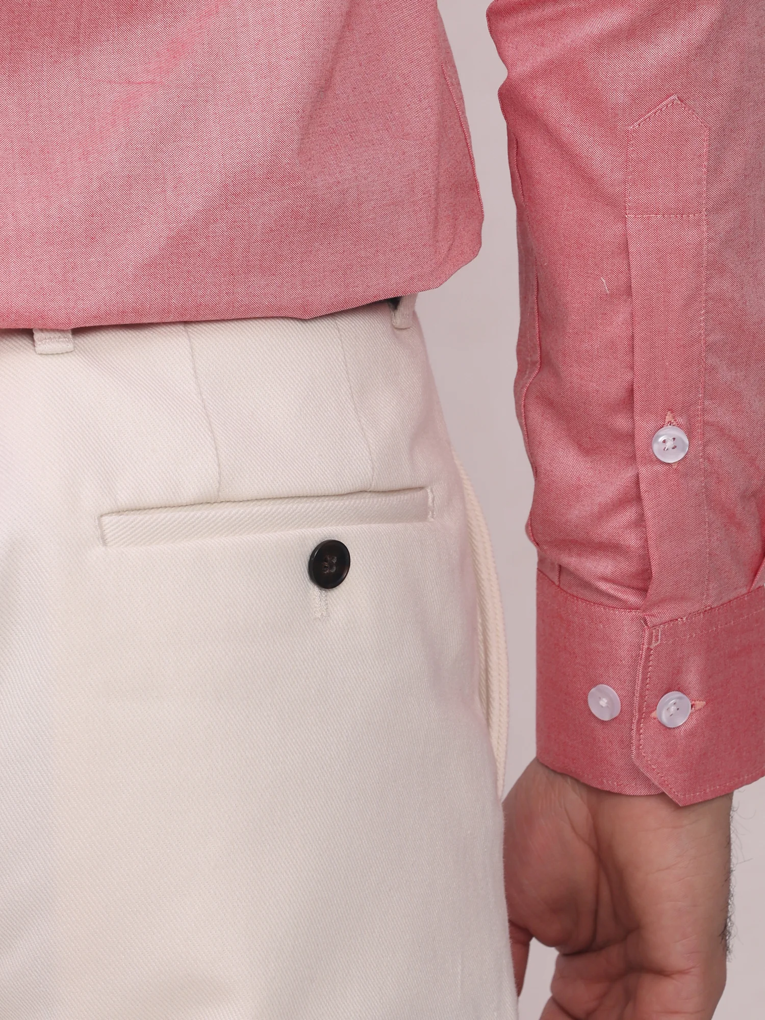 Pink shirt, front, buttons on cuff, side view, with white trousers