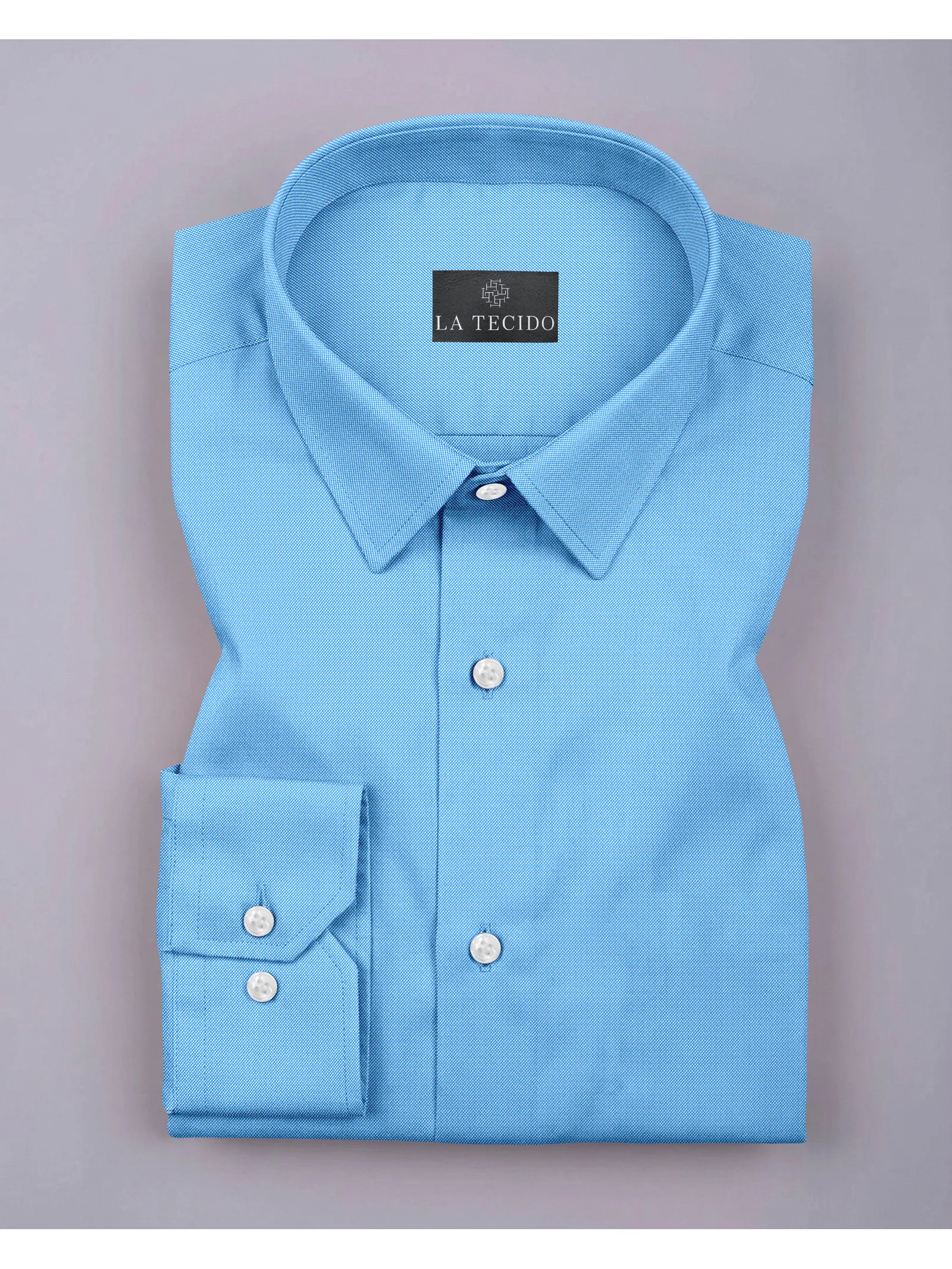 Folded light blue long-sleeve shirt with spread collar and white front buttons, flat lay view