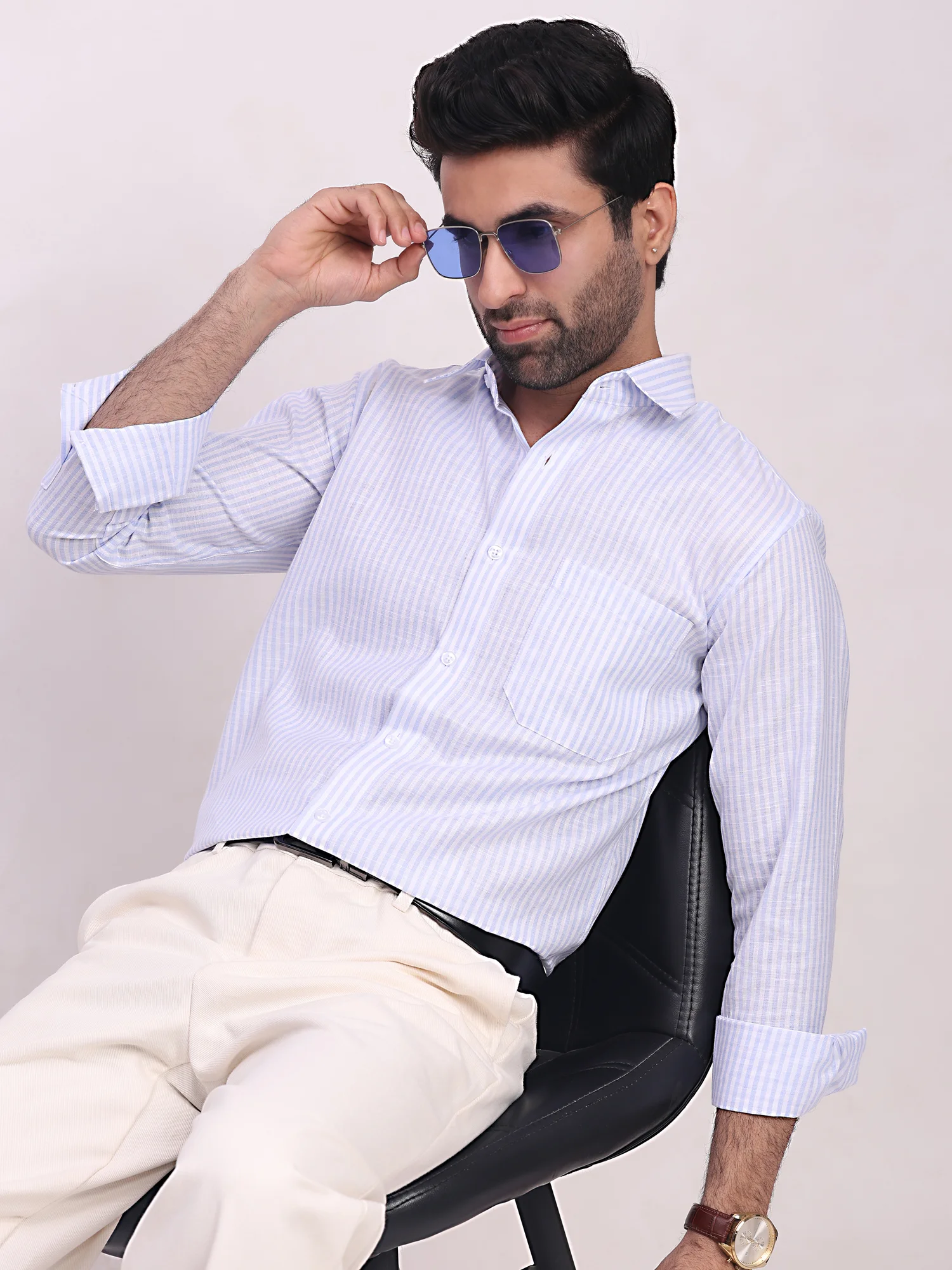 Model wearing a sky blue and white striped long-sleeve shirt with a pointed collar, front buttons, and a chest pocket