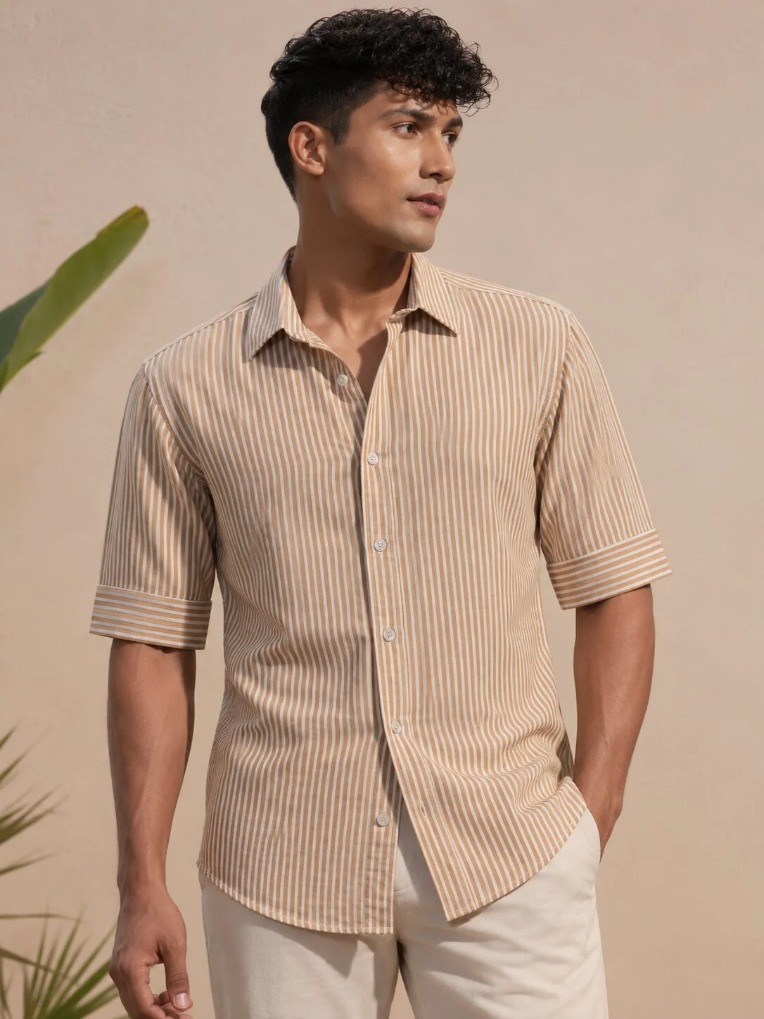 Front view of a model wearing a striped short-sleeve shirt in orange and white, with a collar and buttons