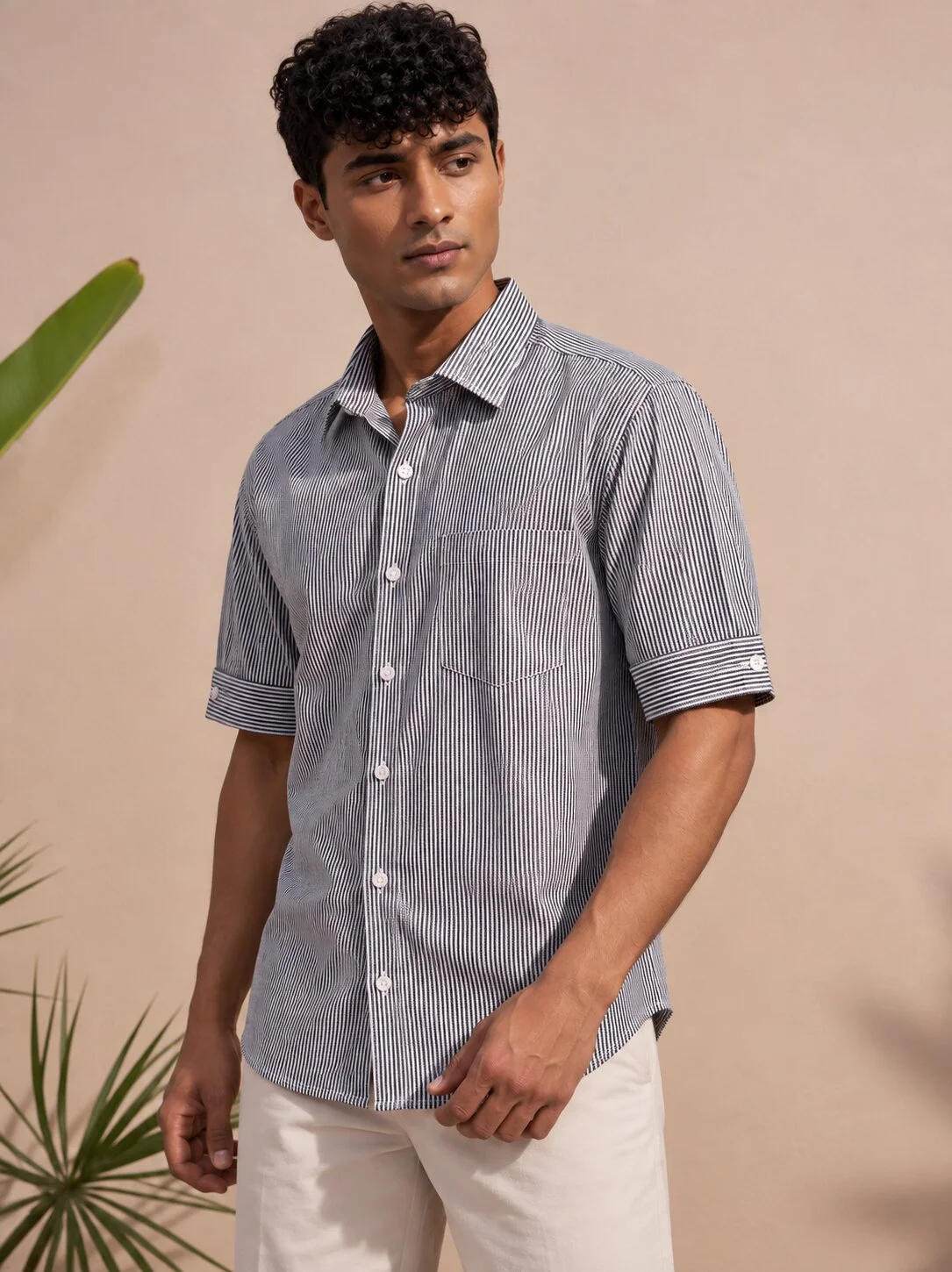 Grey and white striped short-sleeved shirt, front view, worn by a model, with collar, buttons, and breast pocket