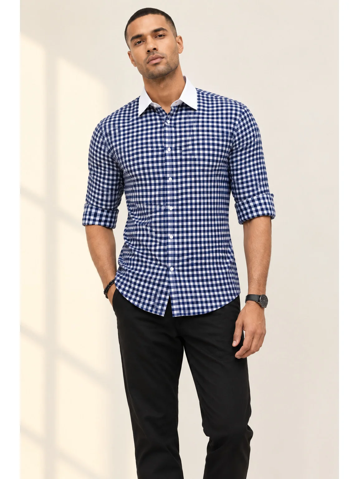 Front view of a model wearing a blue and white checkered shirt with a white collar and rolled-up sleeves