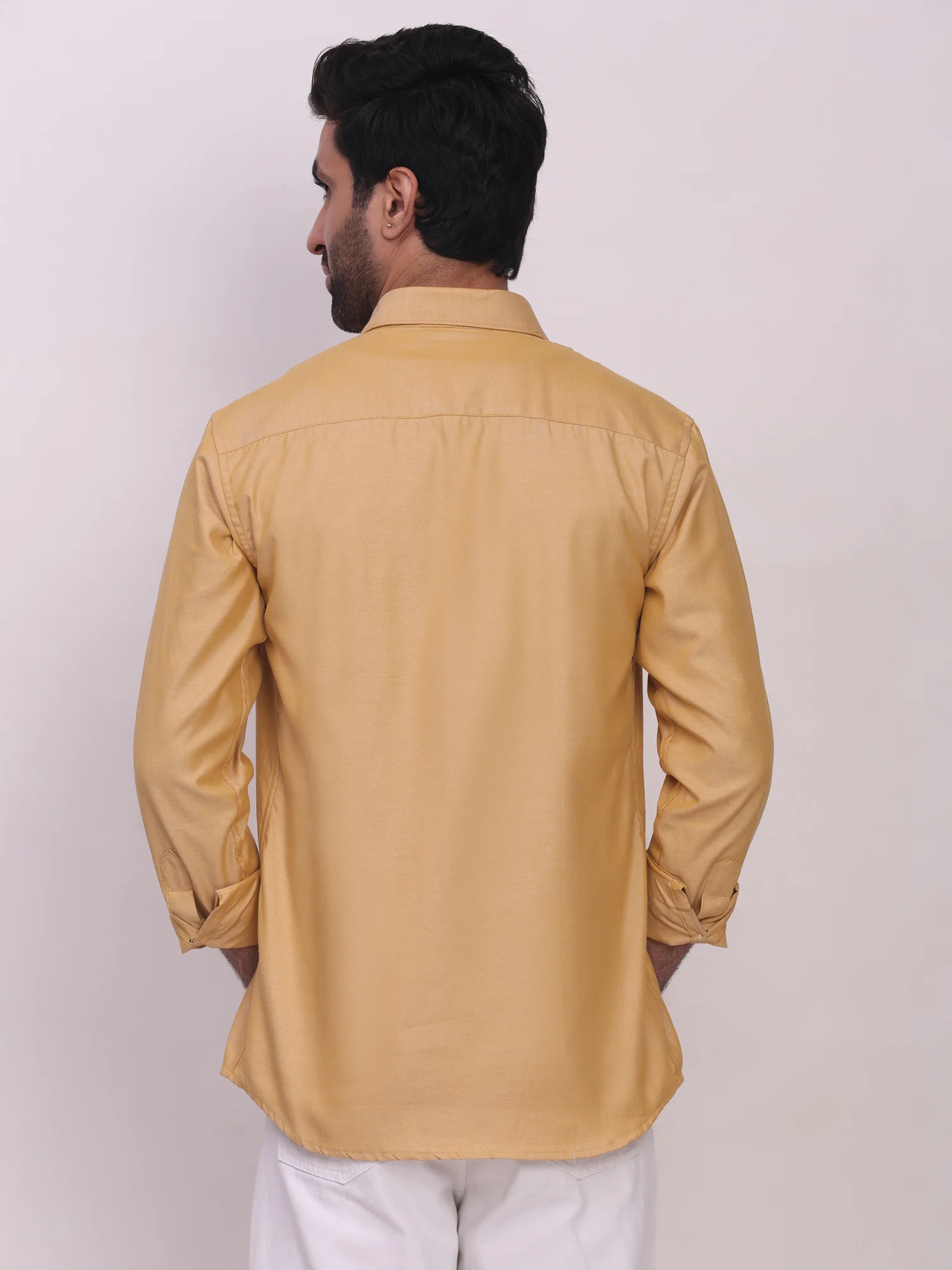 Back view of a model wearing a golden yellow long-sleeve shirt with a collar