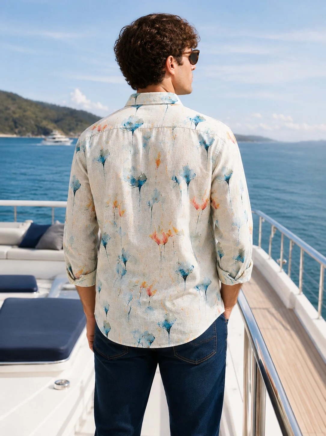 Floral patterned shirt, white base with blue, orange, yellow, back view, worn by a model