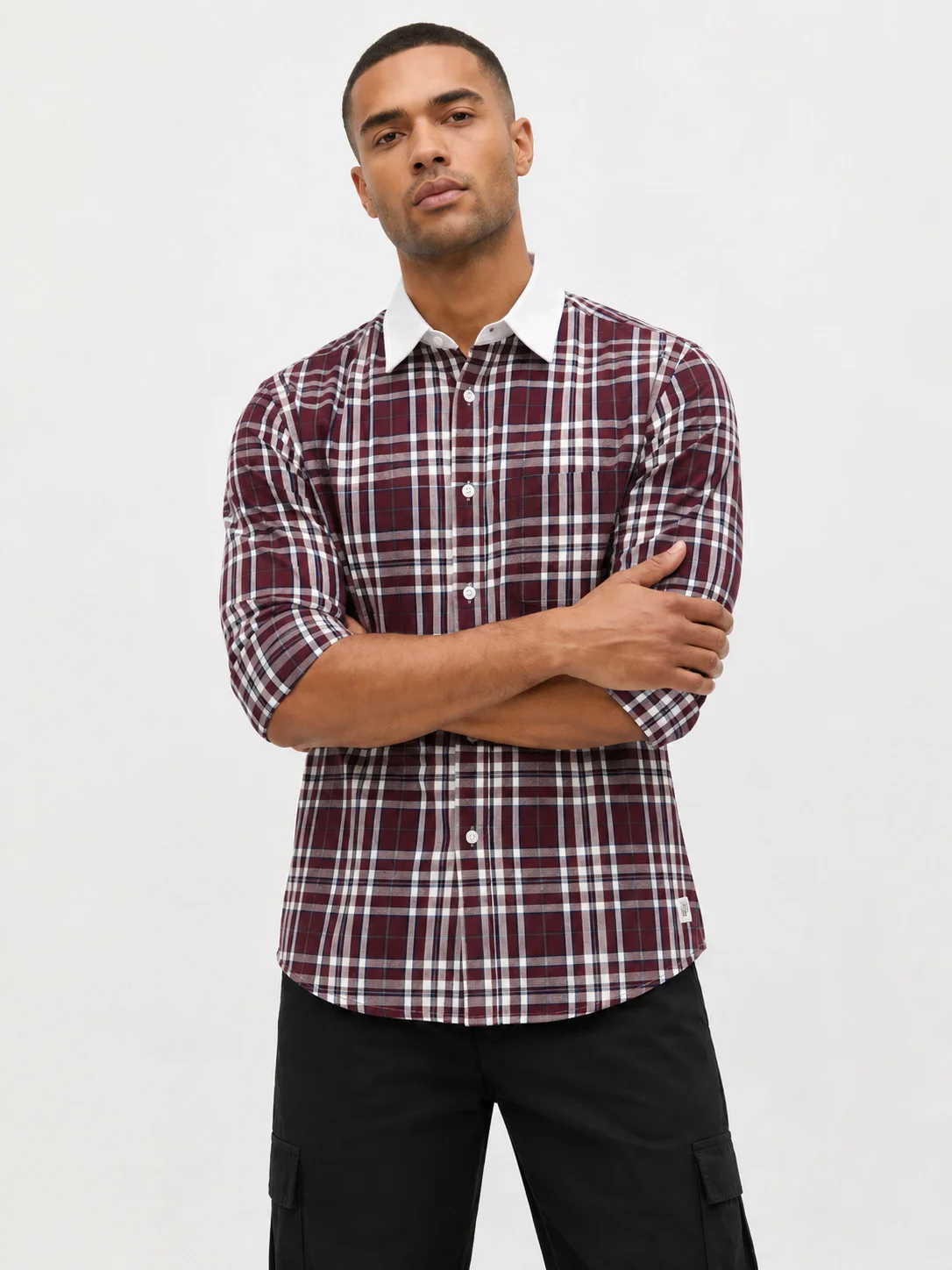 Front view of a model wearing a maroon and white checkered shirt with a white collar and long sleeves