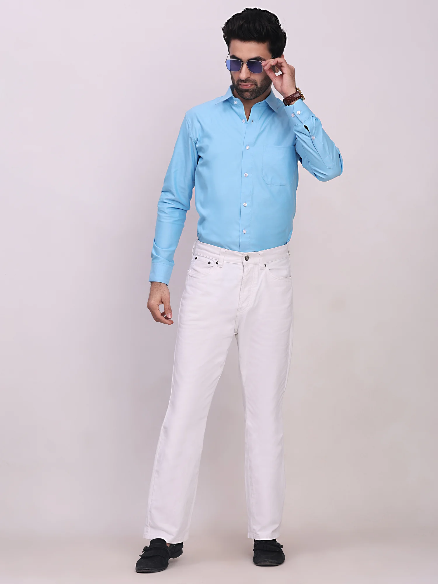 Model wearing blue long-sleeve shirt, collar, button placket, chest pocket, white trousers