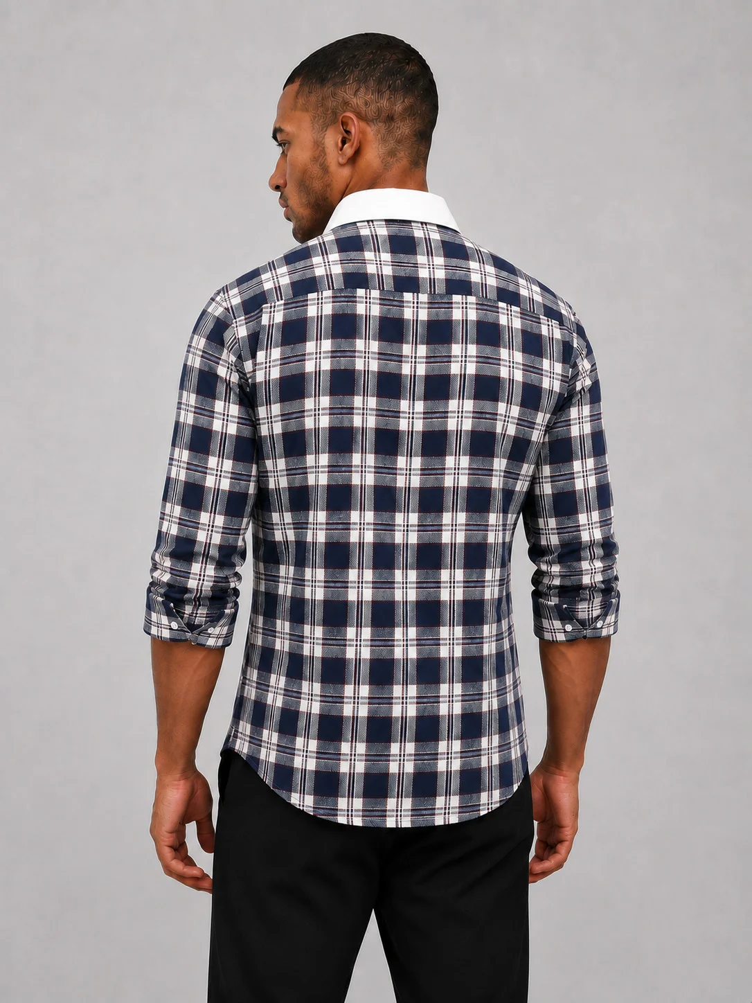 Back view of a model wearing a navy blue checkered full-sleeve shirt with a white collar and black trousers