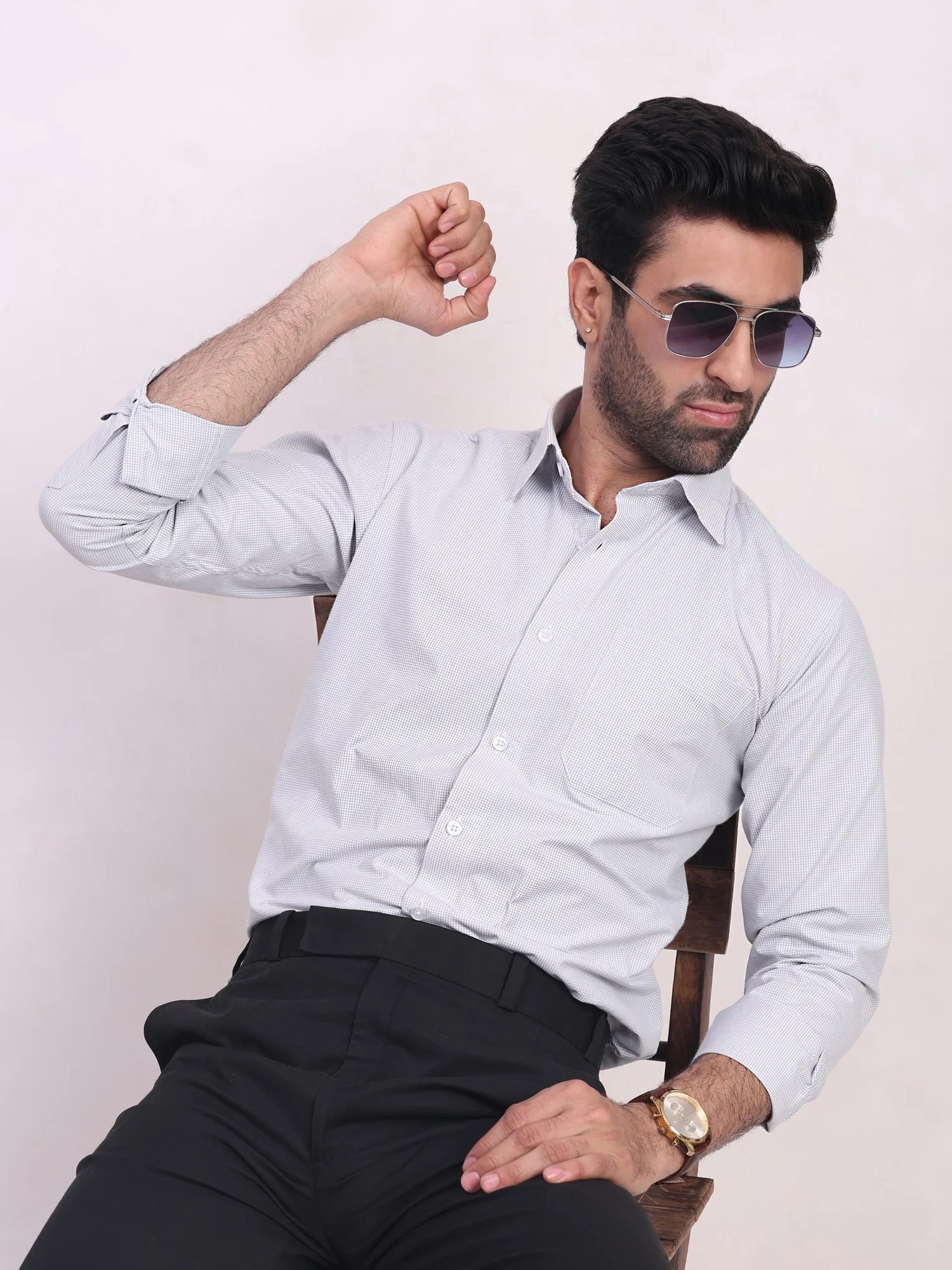 Grey checkered shirt, worn by a model, long sleeves, buttoned cuffs