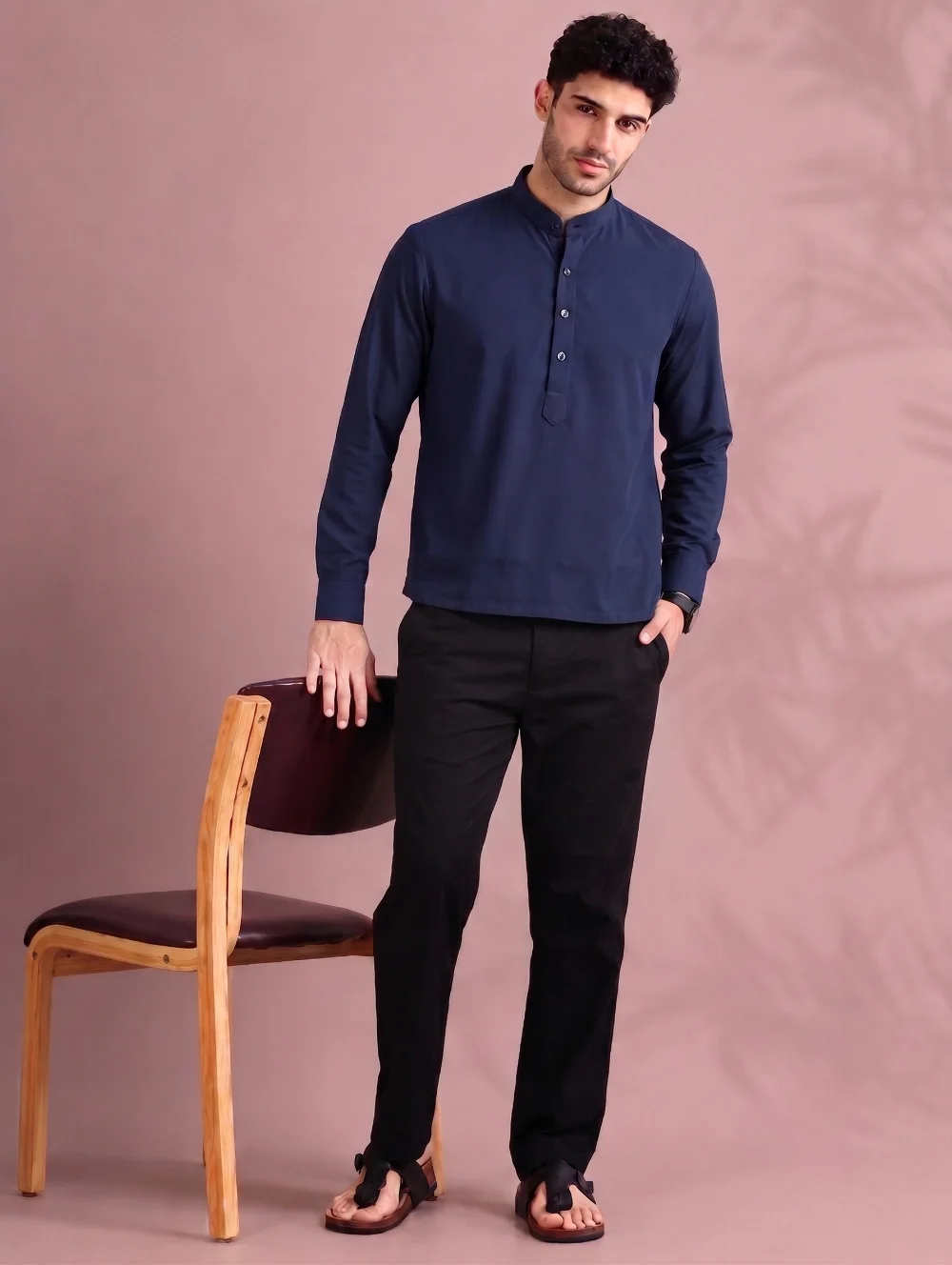 Navy blue kurta with mandarin collar, long sleeves, and buttons, worn by a model