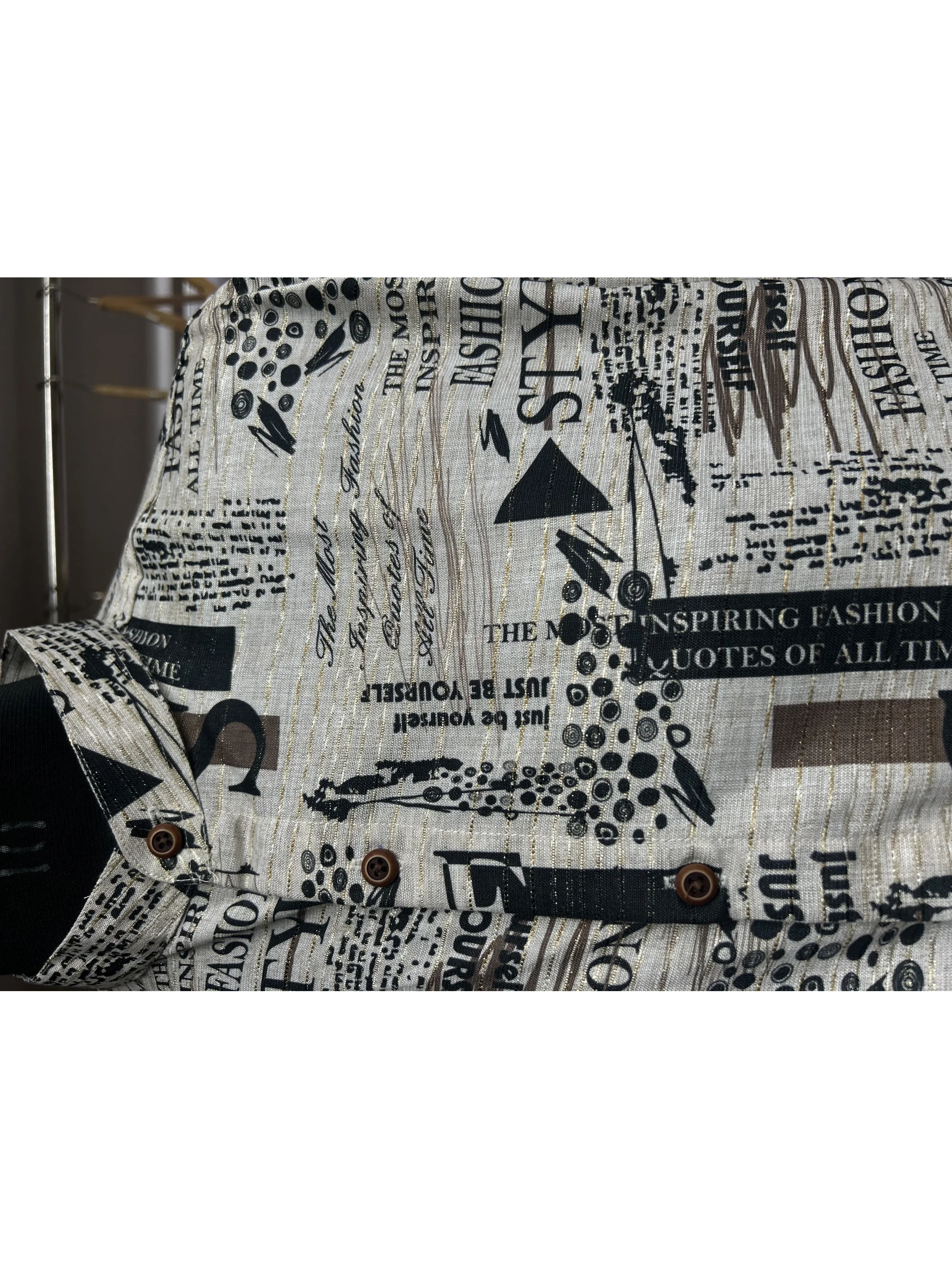 Shirt, beige with black print, front view, buttons, collar visible