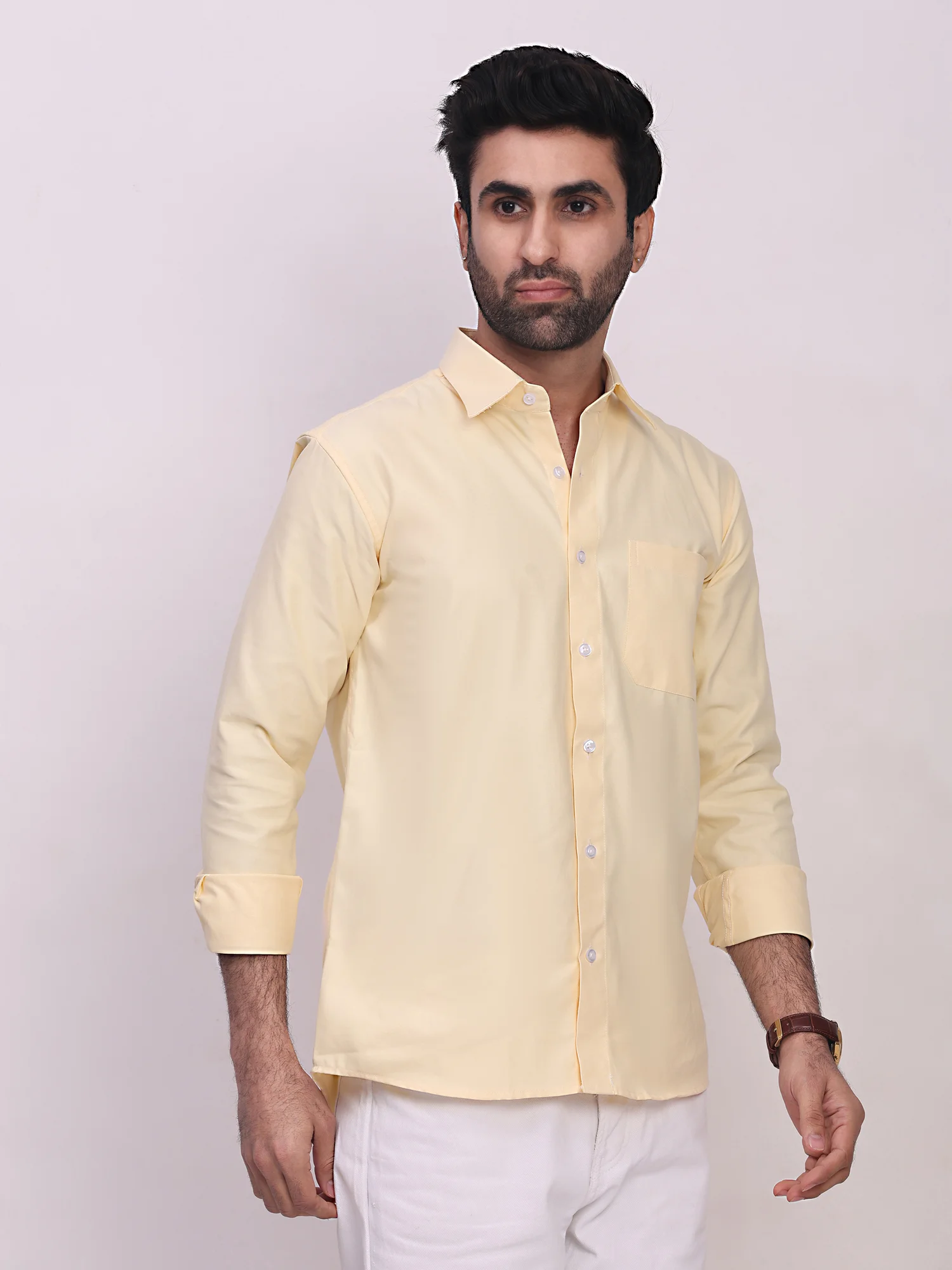 A model wearing a yellow long-sleeve shirt with a pointed collar, front buttons, and a chest pocket