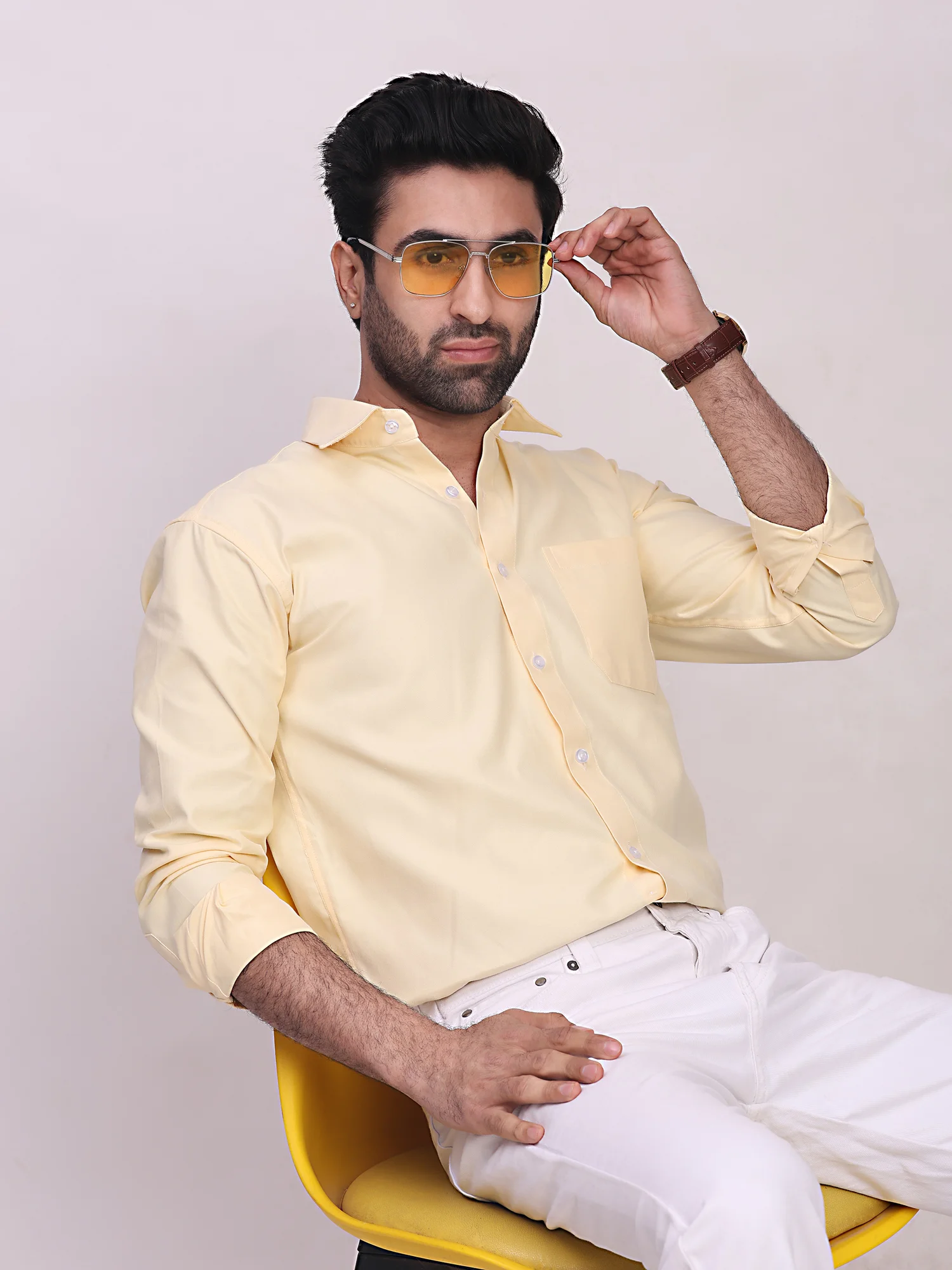 Front view of a model wearing a light yellow long-sleeve shirt with a collar and chest pocket