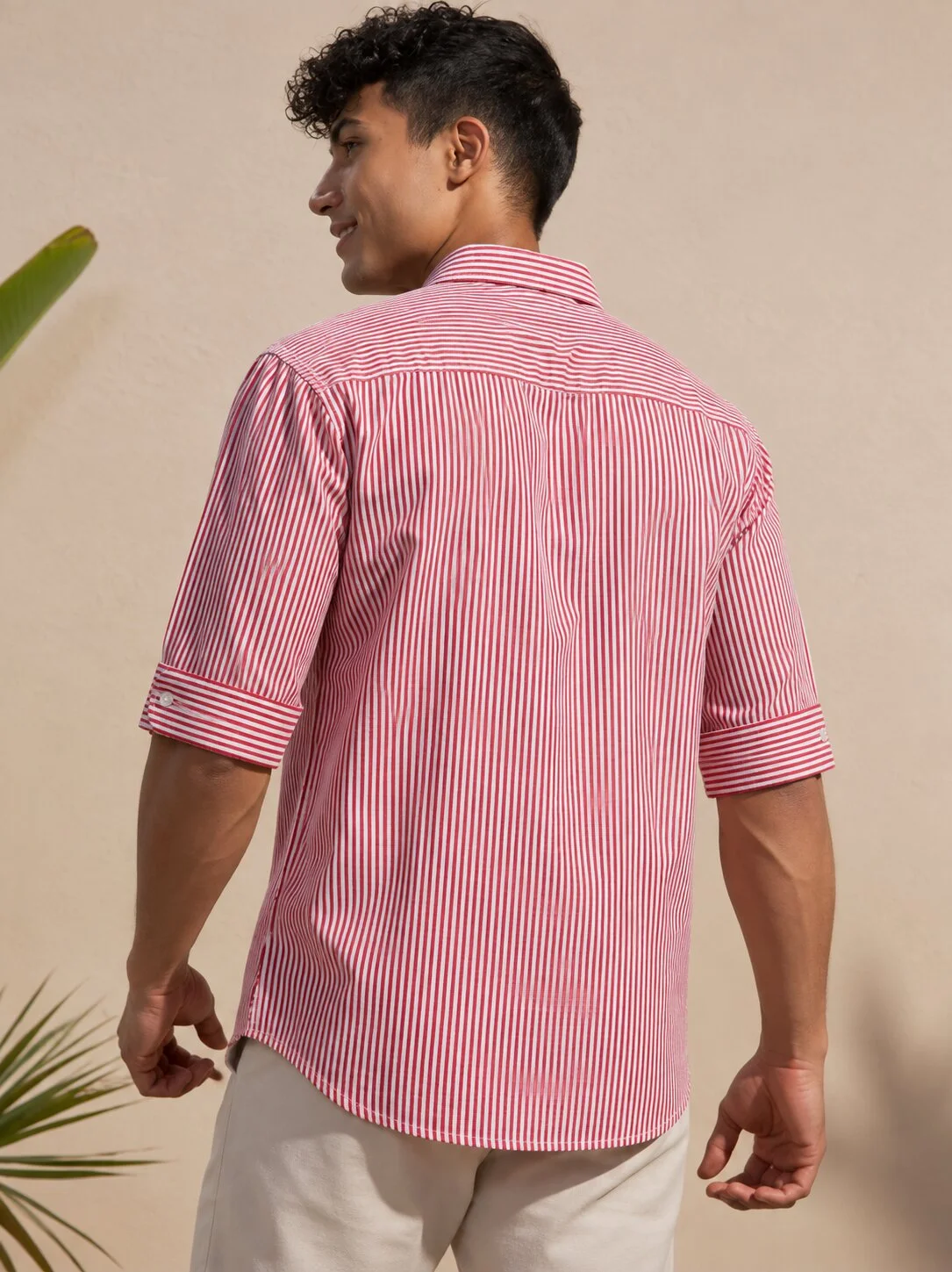 Pink and white striped short-sleeved shirt, back view, on a model