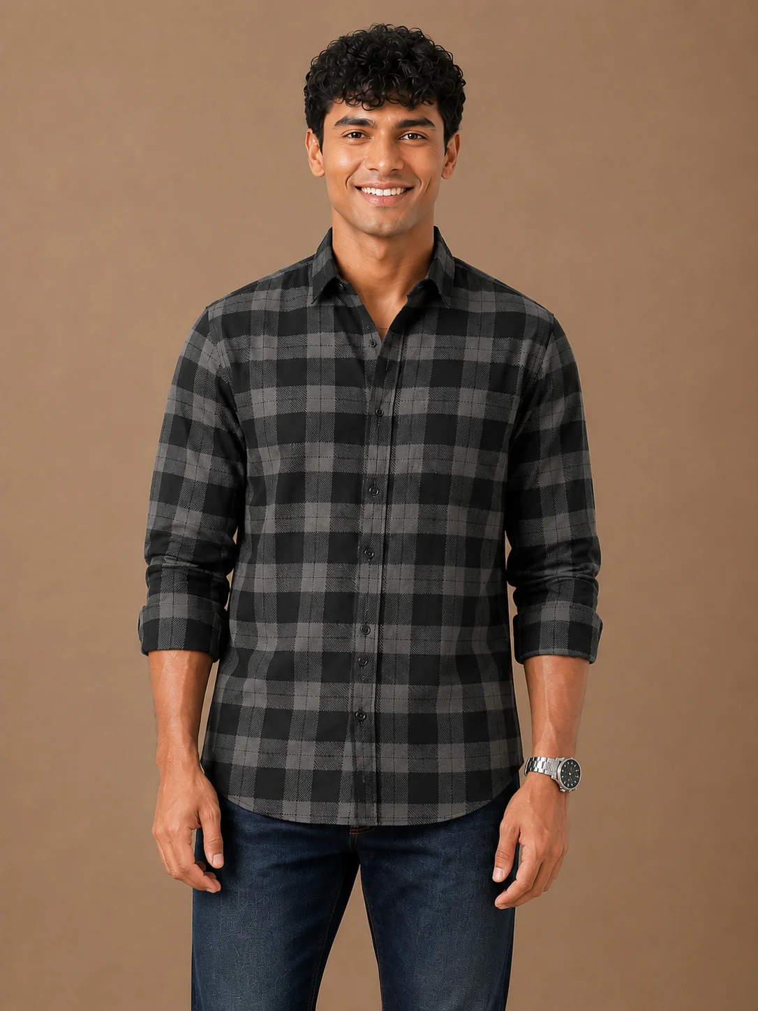 Black and grey check shirt, front view, worn by a model, collar spread, buttons fastened, sleeves rolled