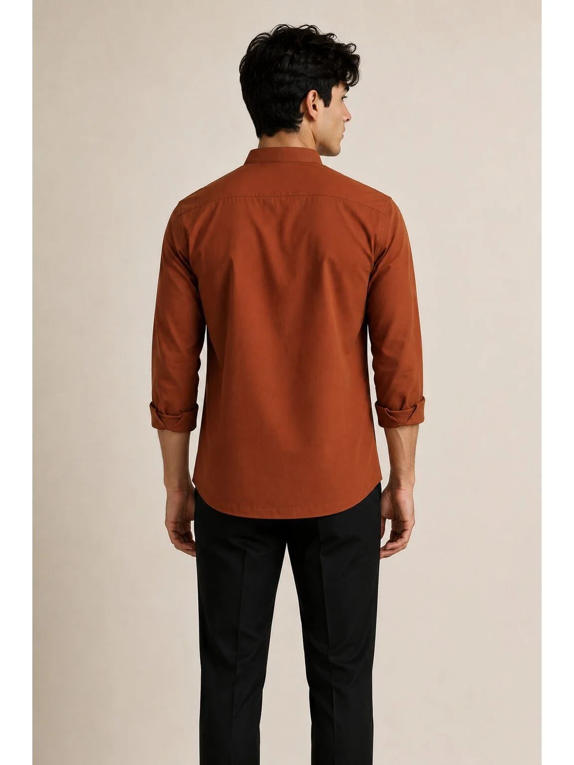 Back view of a male model wearing a rust brown short kurta and black trousers