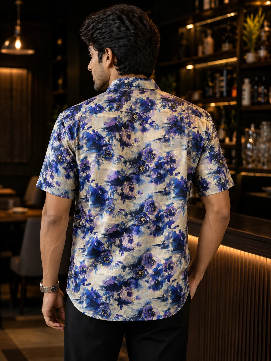 Blue, grey and white floral print short-sleeve shirt, back view, worn by a model
