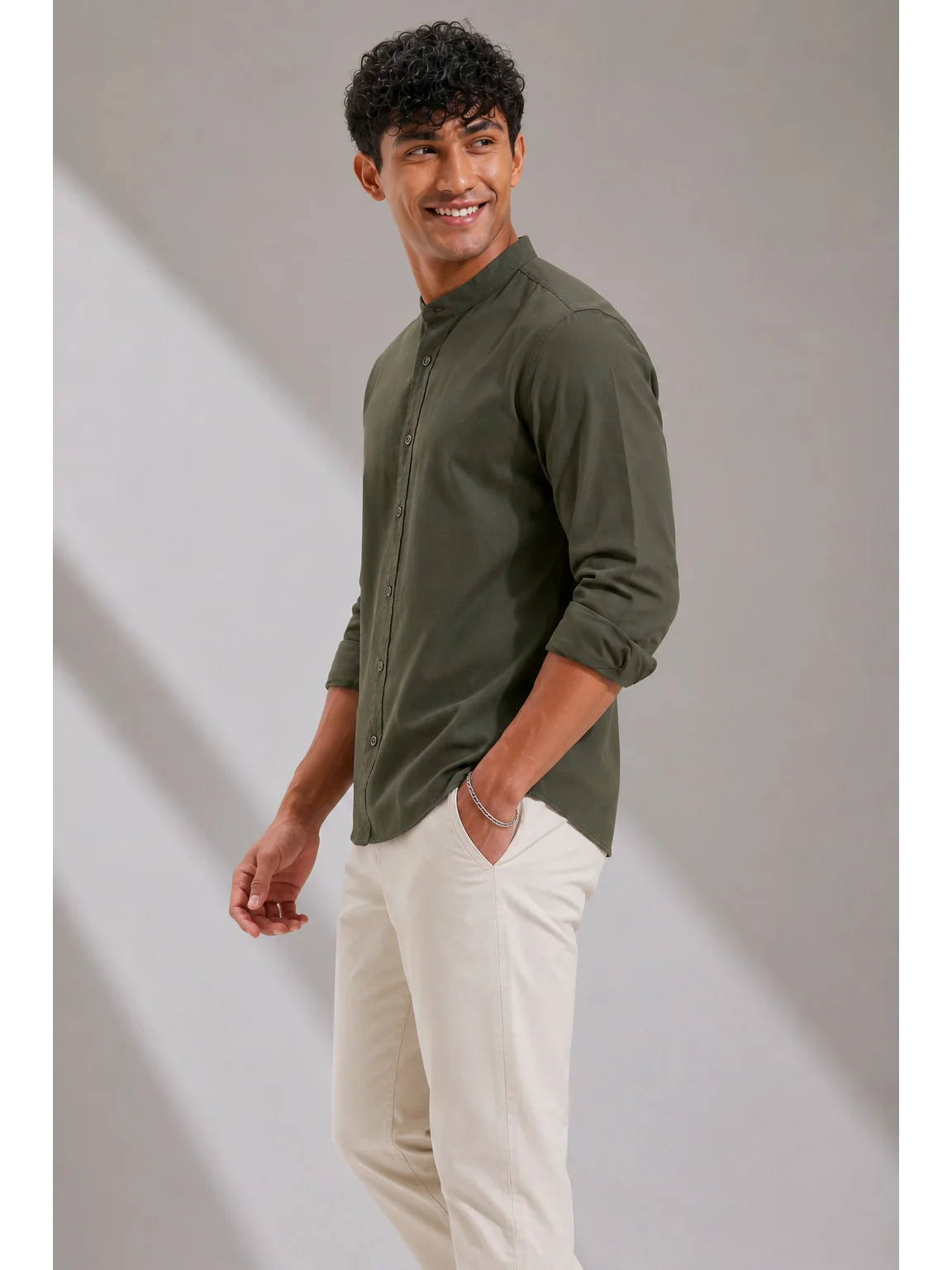 Side view of a dark olive green shirt kurta worn by a model with cuffed long sleeves and a mandarin collar