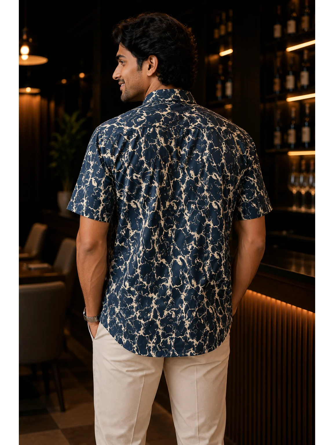 Short-sleeved shirt, navy blue and beige abstract print, back view, worn by a model
