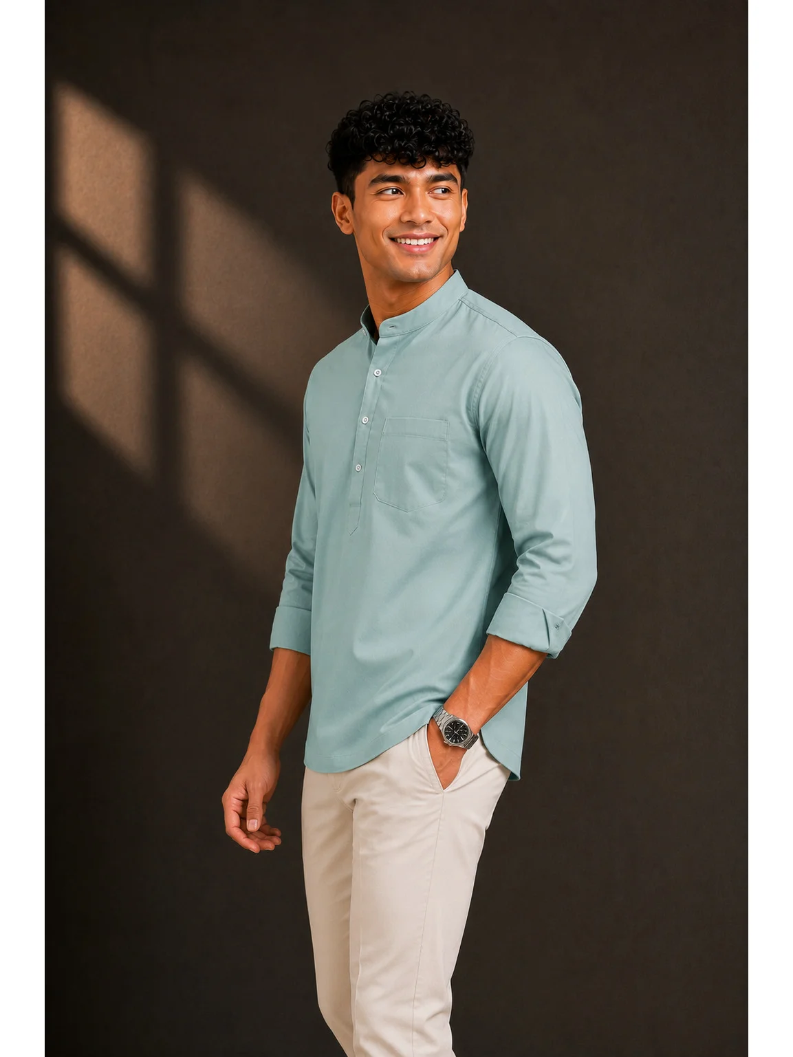 Model wearing a sea green short kurta with mandarin collar, chest pocket and rolled-up sleeves, side view