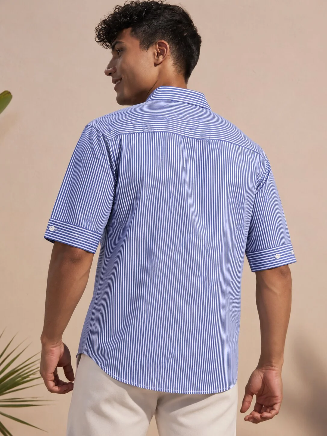 Blue and white striped short-sleeved shirt, back view, worn by a model