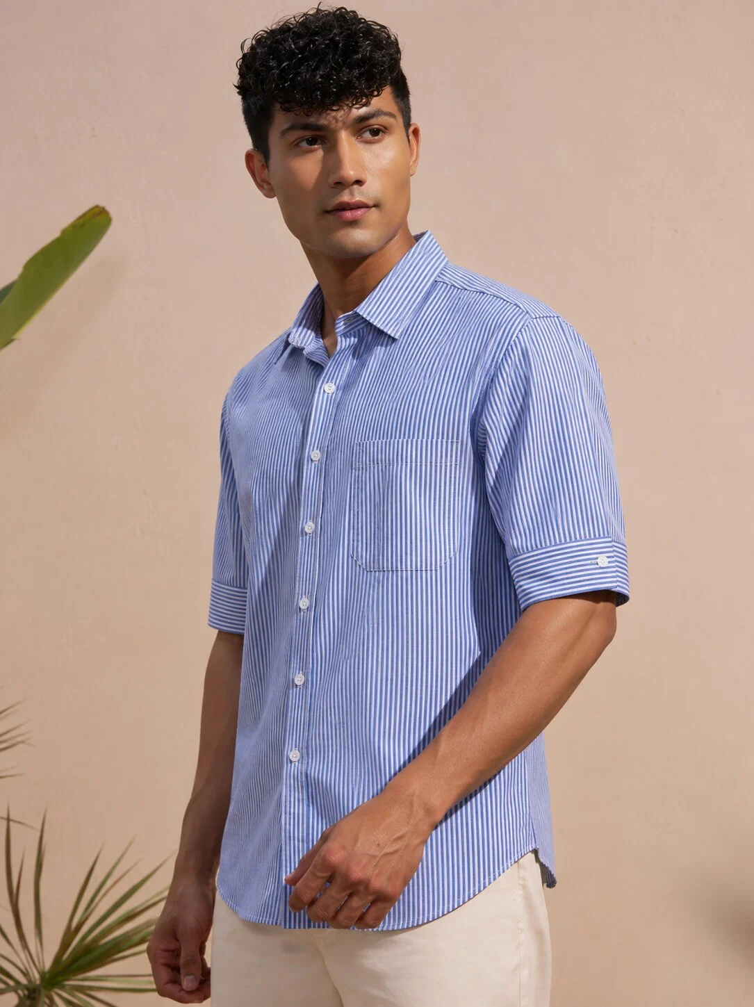 Blue and white striped short-sleeved shirt, collar, buttons, chest pocket, worn by a model
