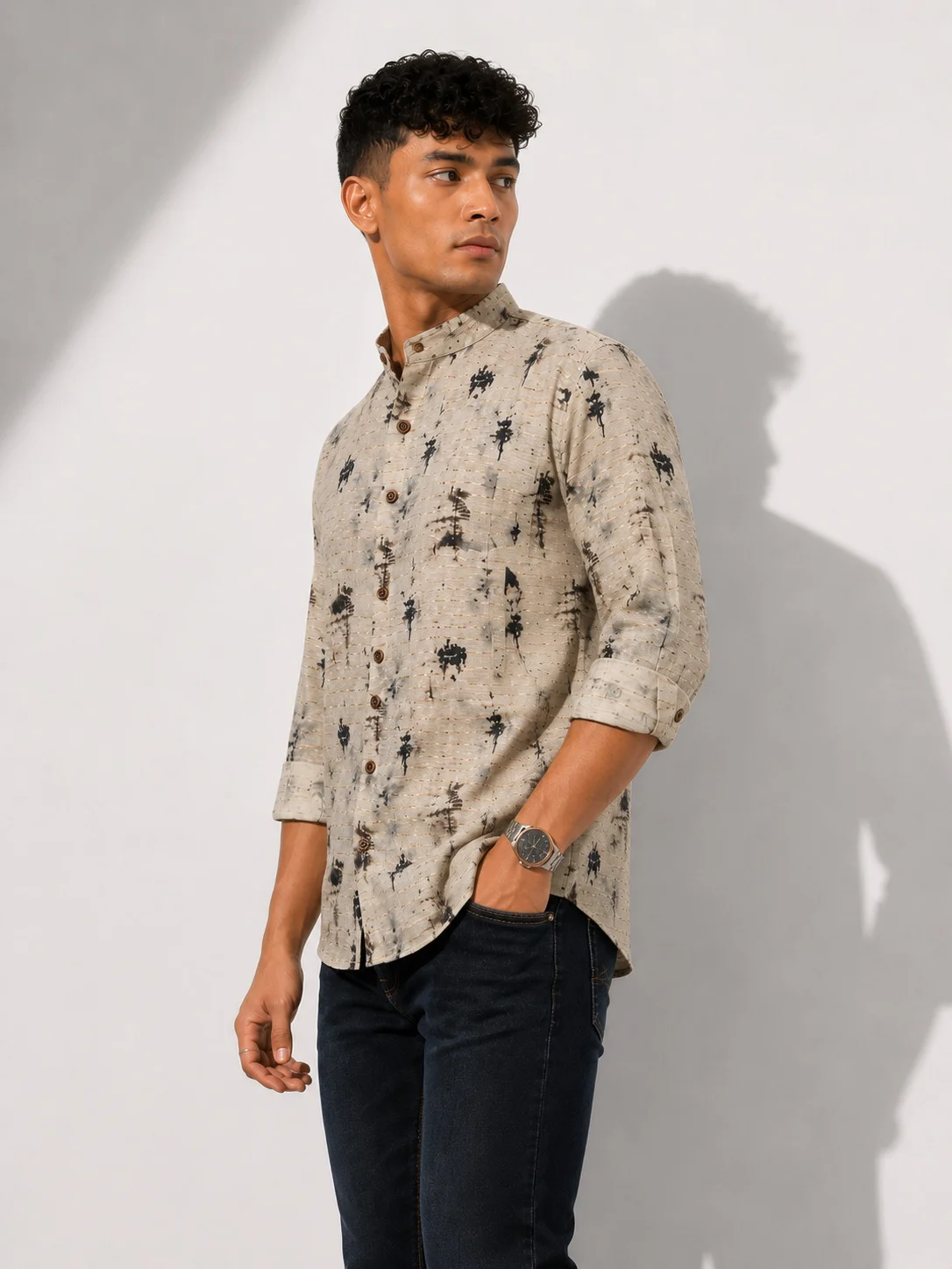 Beige and black patterned shirt, front view, worn by a model, mandarin collar, buttons, rolled sleeves