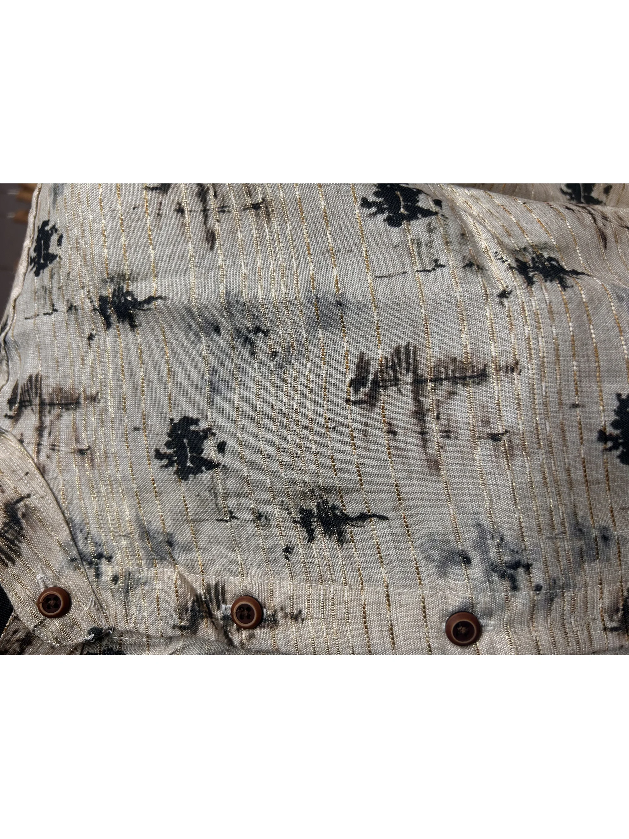 Shirt, beige with black abstract print, close-up of buttons on chest pocket