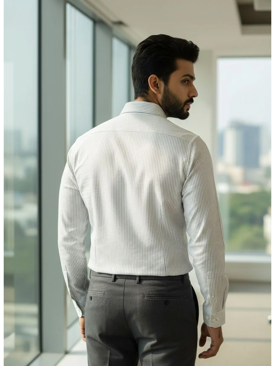 Back view of a man wearing a sky blue striped long-sleeve shirt and grey trousers
