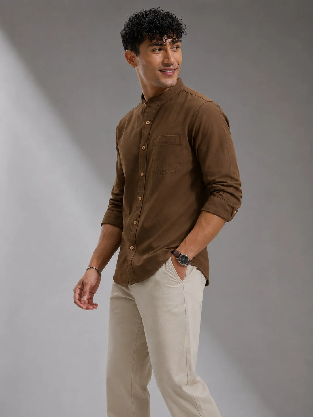 Model wearing a coffee brown long-sleeve short kurta with Mandarin collar, front placket buttons, and chest pocket