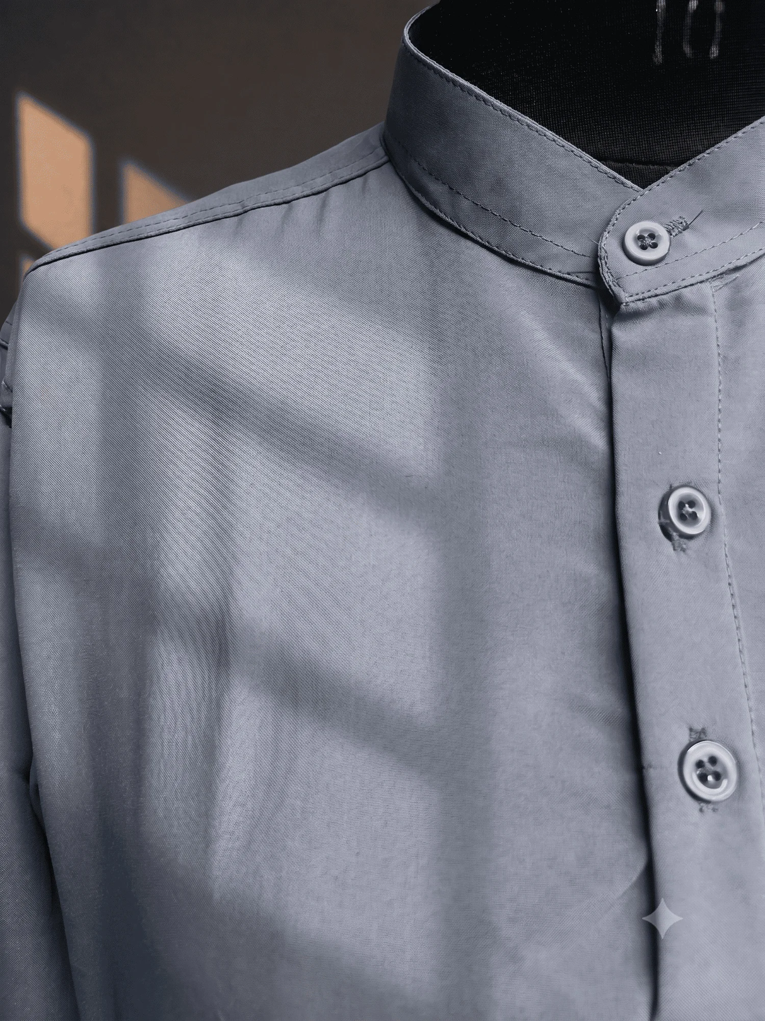 Close-up of a charcoal grey kurta with a mandarin collar and buttons