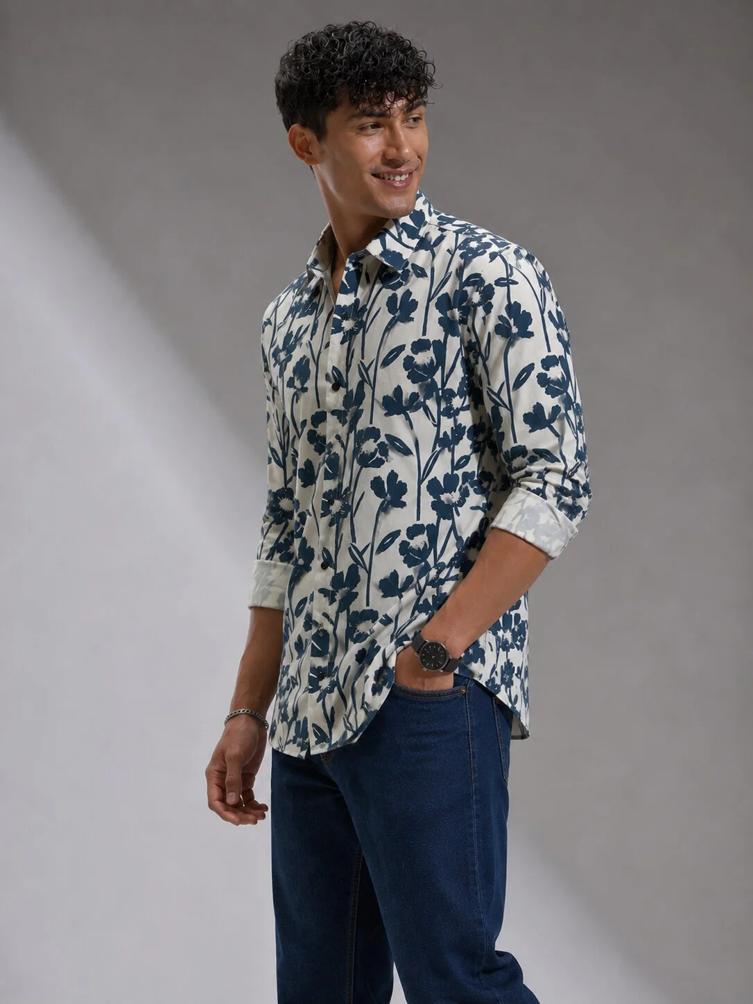 White and blue floral printed shirt, worn by a model, front view, collar, buttons, pockets, rolled sleeves visible