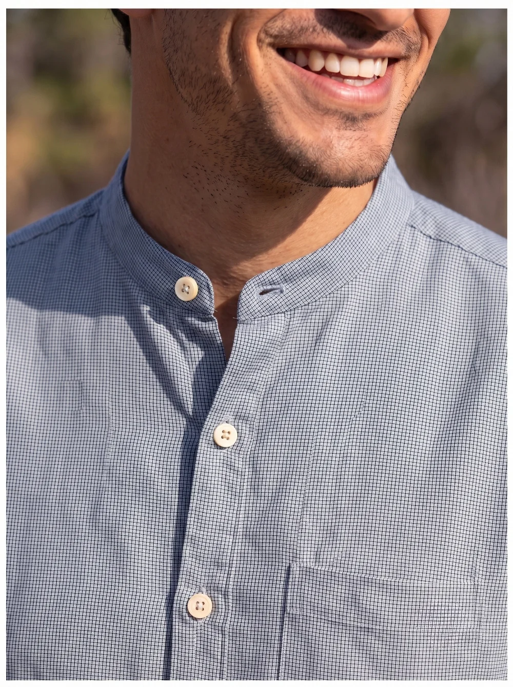 Blue checked kurta, mandarin collar, buttoned front, one pocket visible, worn by a model, close-up