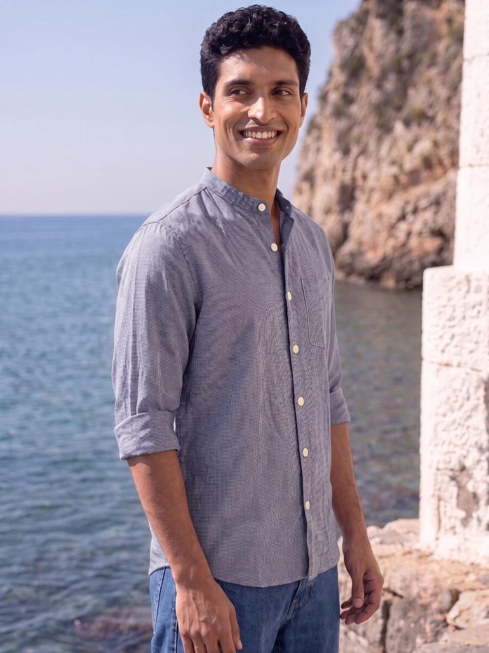 Long sleeve shirt, blue-grey colour, mandarin collar, buttoned front, rolled sleeves, worn by a model