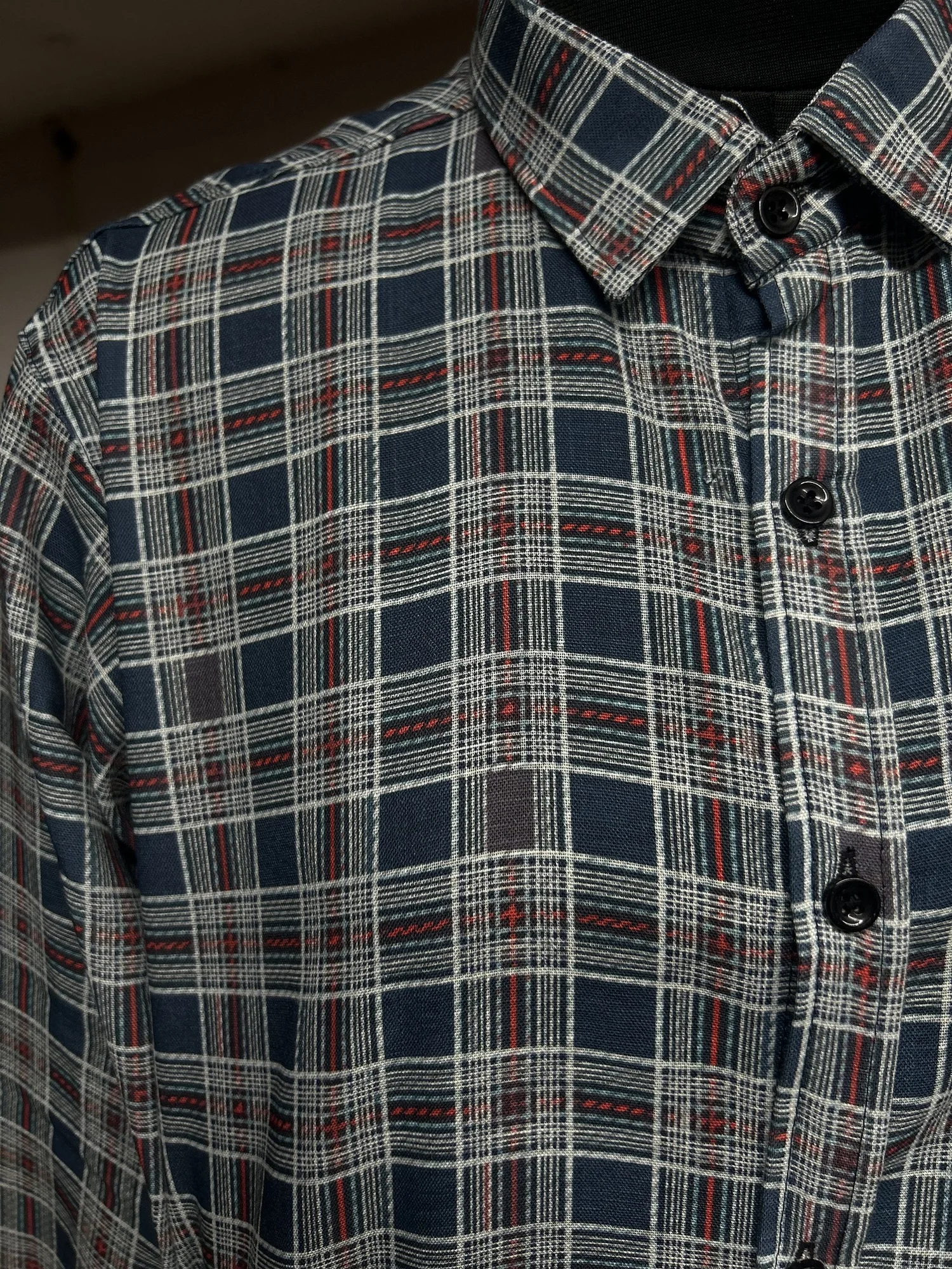 Navy blue, red, and white checkered shirt, collar and buttons visible, front view